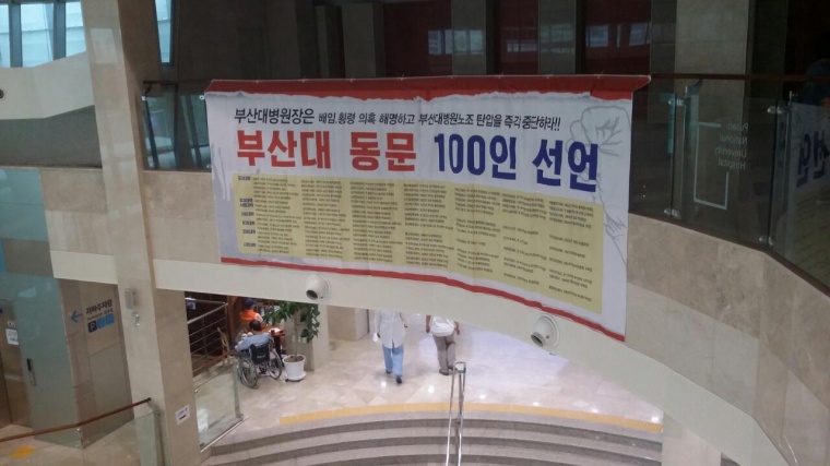 부산대병원 로비에 100인 선언 대형 걸개플랑이 게시되어 있다@보건의료노조