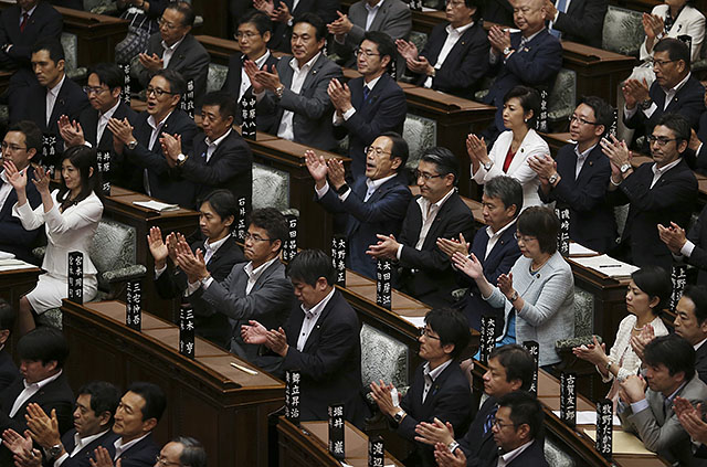 ▲ 연립여당인 자민당과 공명당 소속 의원들이 19일 새벽 법안 통과가 결정된 이후 환영의 박수를 치고 있다. ⓒAP=연합뉴스